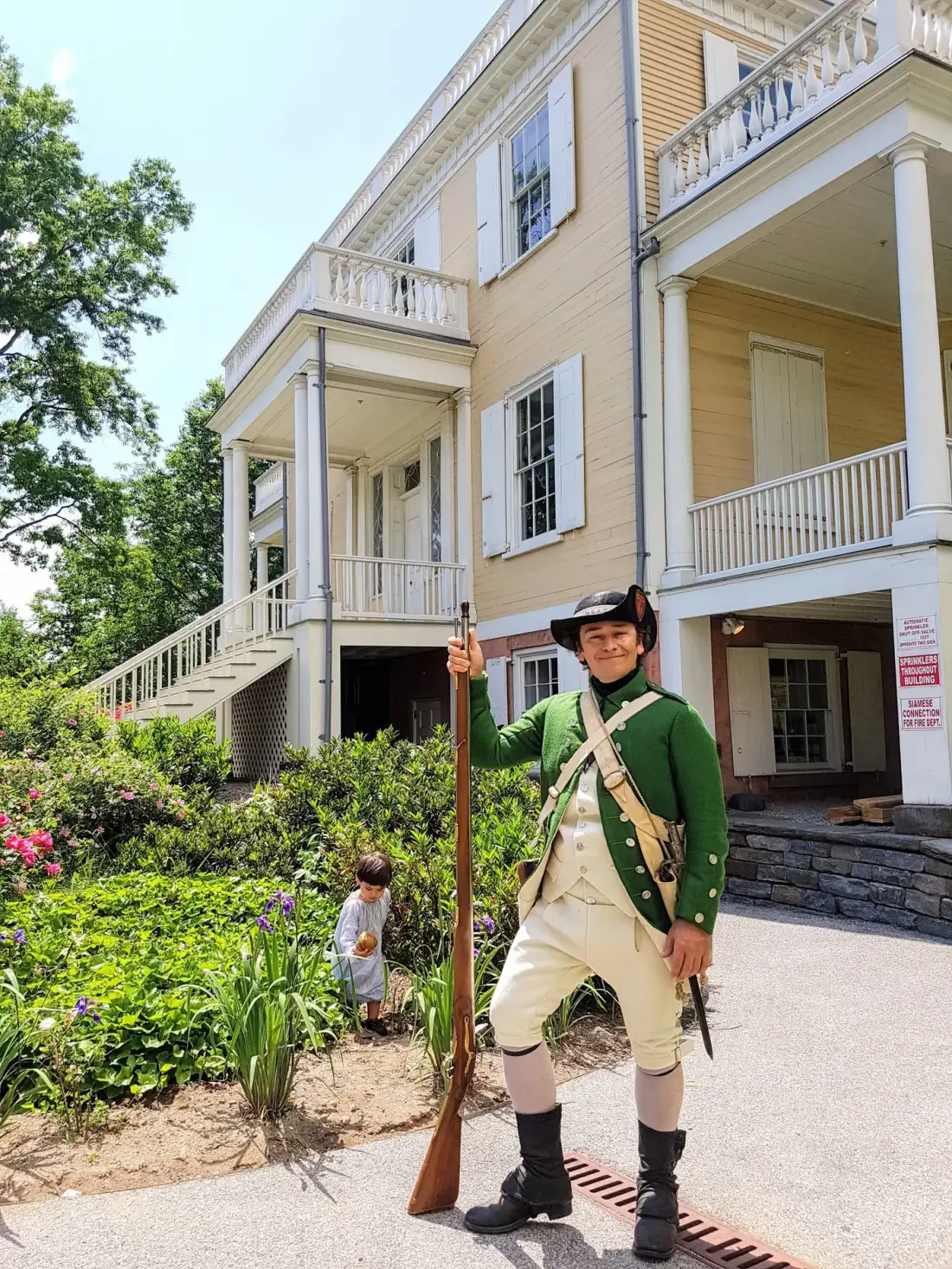 Outside a colonial house with musket