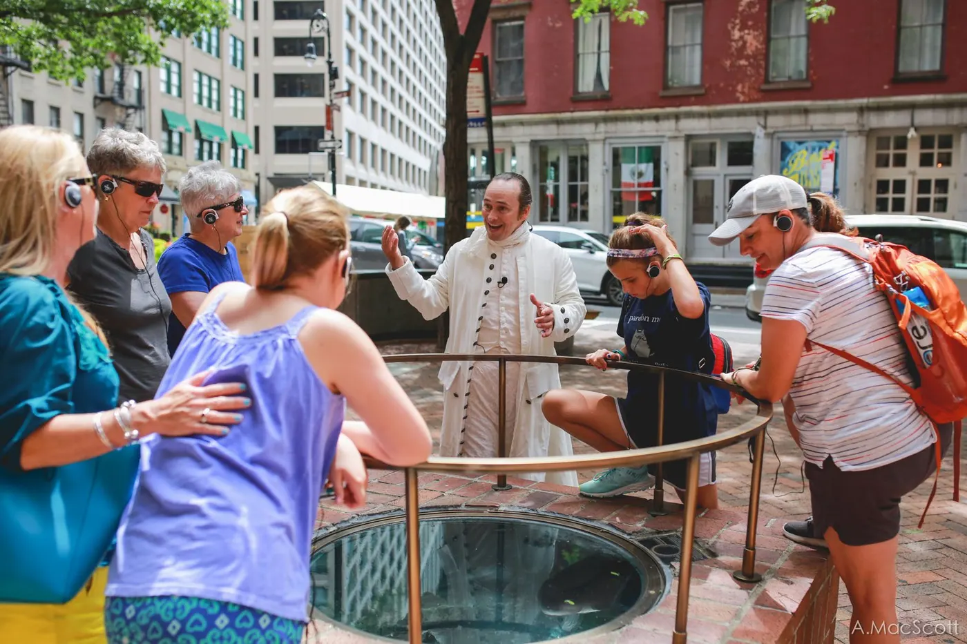 Hamilton talking with walking tour guests beside a colonial well